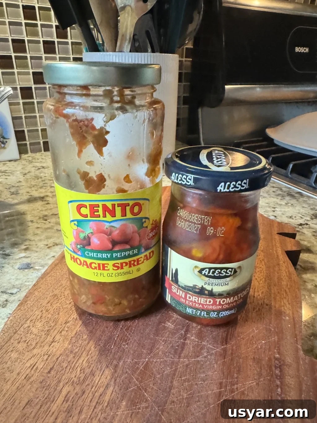 Open-Faced Italian Subs Recipe with Melty Mozzarella 6 A jar of cherry pepper hoagie spread next to a jar of sun dried tomatoes in extra virgin olive oil.