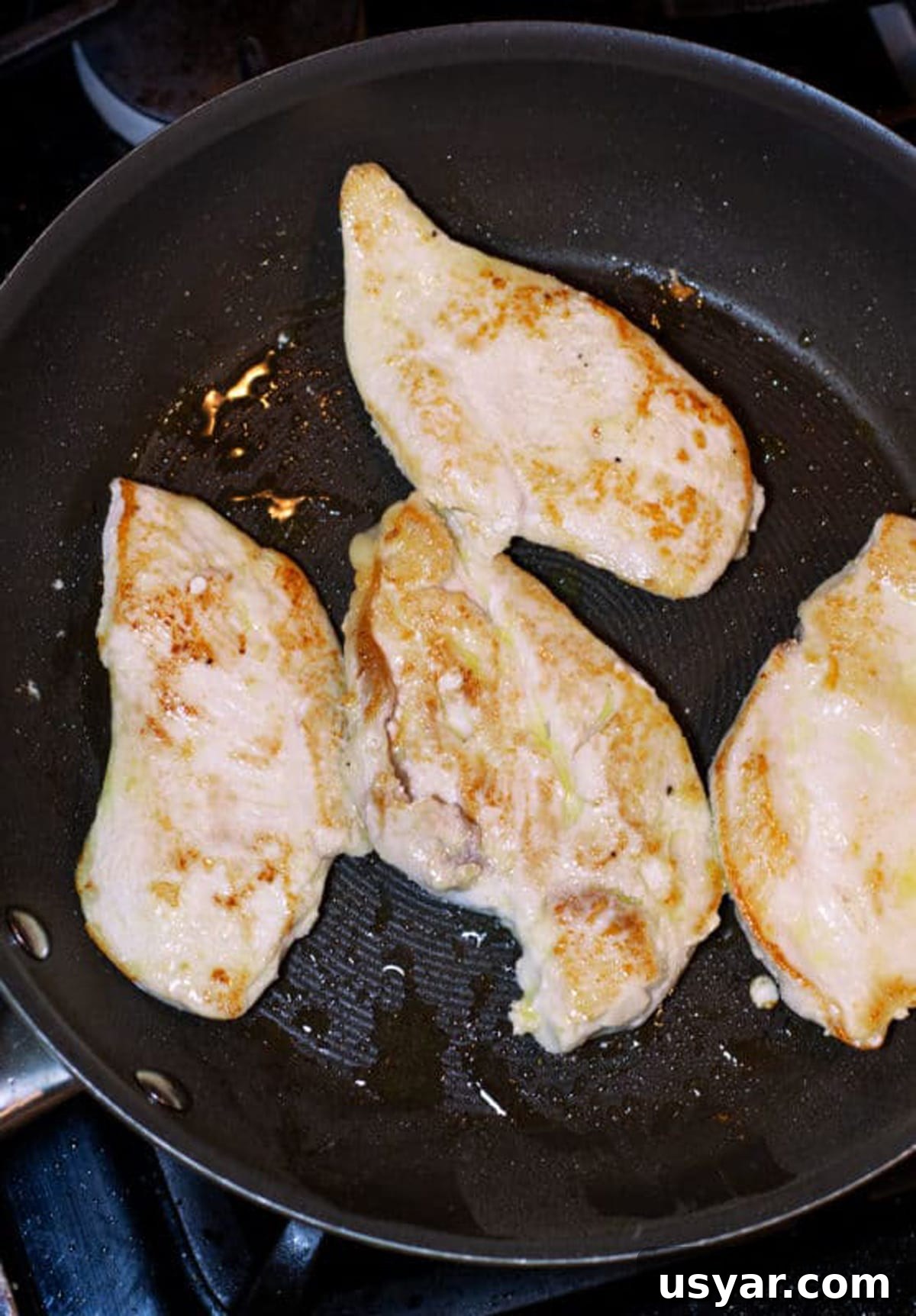Baked Chicken Caprese with Mozzarella and Tomatoes 5 Sauteing 4 chicken breasts in a black skillet.