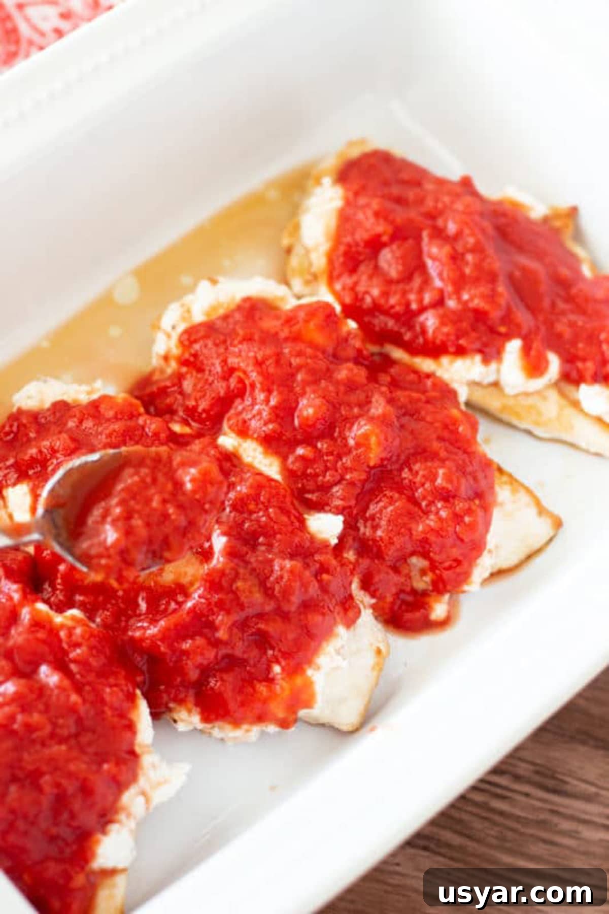 Baked Chicken Caprese with Mozzarella and Tomatoes 8 Spoonful of of crushed tomatoes topping ricotta covered chicken breasts.