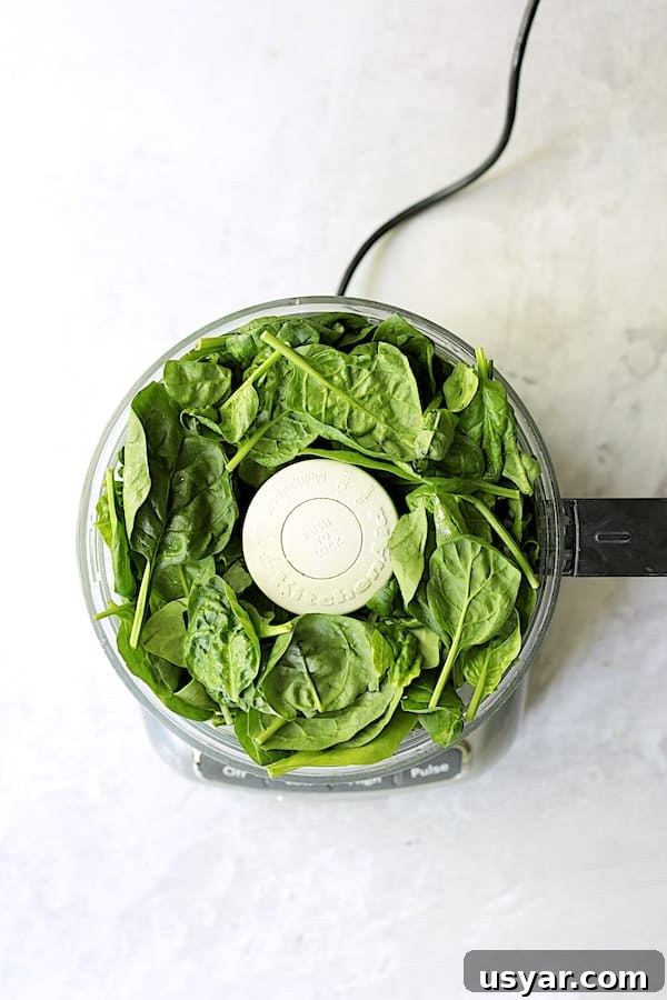 Oven-Baked Tilapia with Spinach Pecan Pesto Recipe 5 Photo of spinach leaves in food processor.