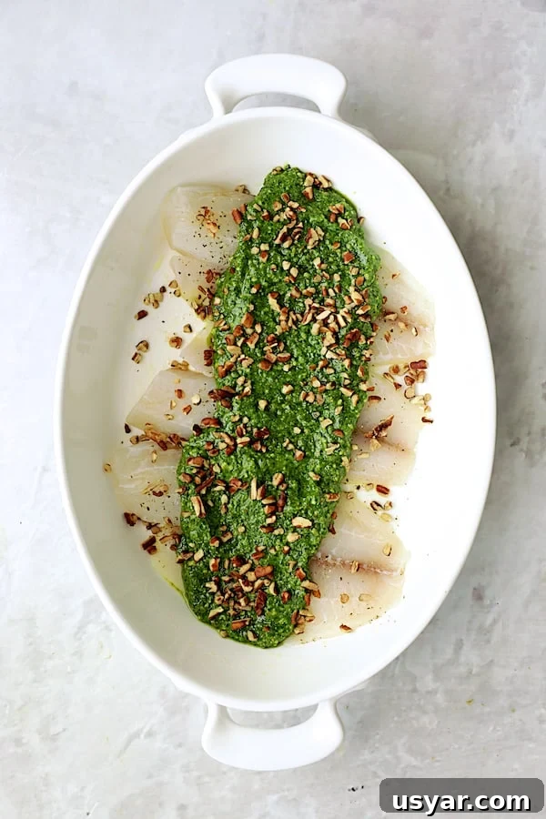 Oven-Baked Tilapia with Spinach Pecan Pesto Recipe 6 Photo of uncooked tilapia with pesto over the top.