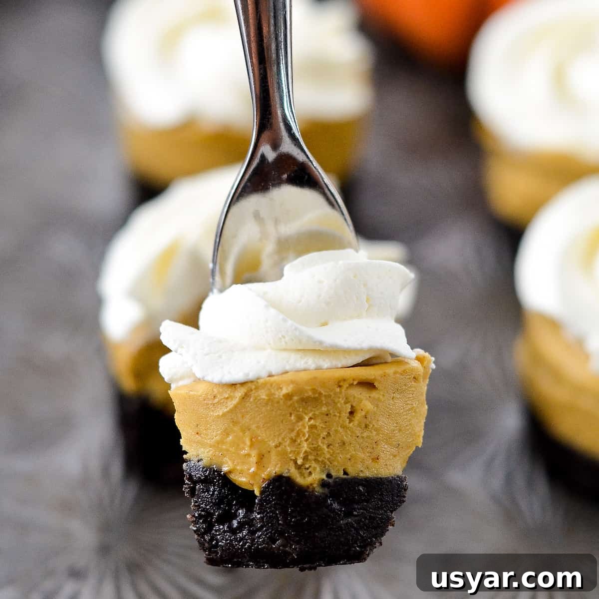 No-Bake Mini Vegan Pumpkin Pies are the perfect elegant fall dessert! They are gluten-free, dairy-free, refined sugar free, paleo, vegan and SUPER easy to make! #vegan #pumpkinpie #nobake #dessert #paleo #glutenfree #dairyfree 5 vegan pumpkin bites with one being lifted in air with a fork.