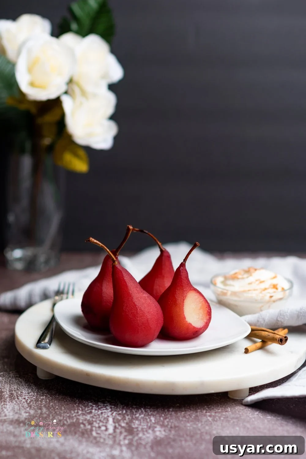 Red Wine Poached Pears Recipe with Vanilla and Cinnamon 2 Image of pears in wine dessert on a white serving plate