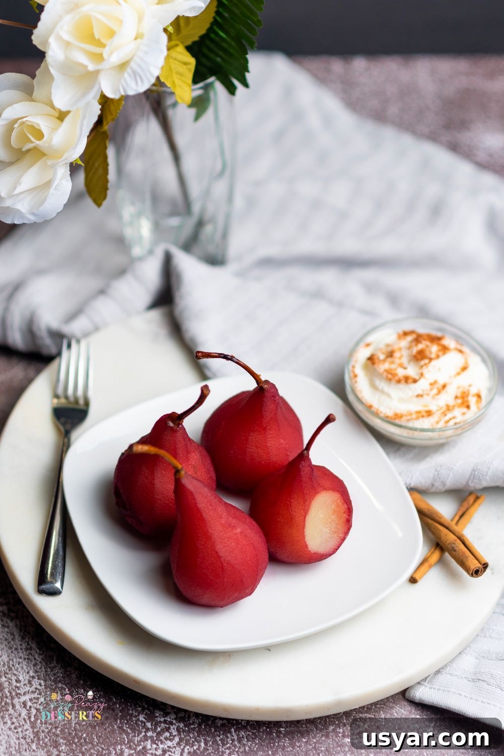 Red Wine Poached Pears Recipe with Vanilla and Cinnamon 3 Image of pears in red wine on a white serving plate