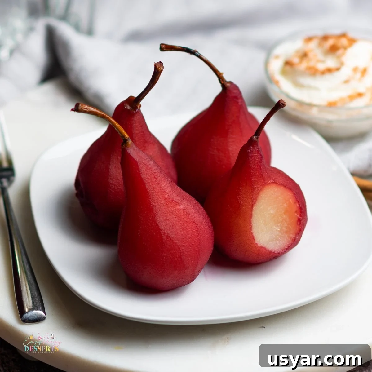Red Wine Poached Pears Recipe with Vanilla and Cinnamon 4 Close up image of wine poached pears on a white serving plate