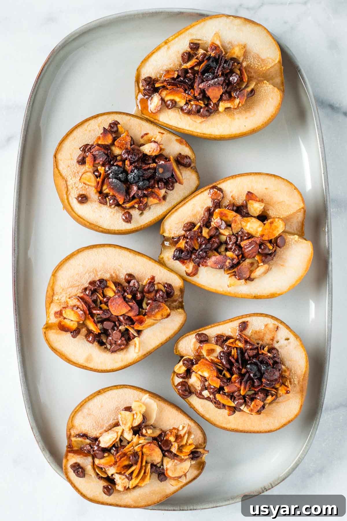 Oven Baked Pears with Almonds and Dark Chocolate 11 Platter with baked, stuffed pears with melty chocolate and almond mixture.