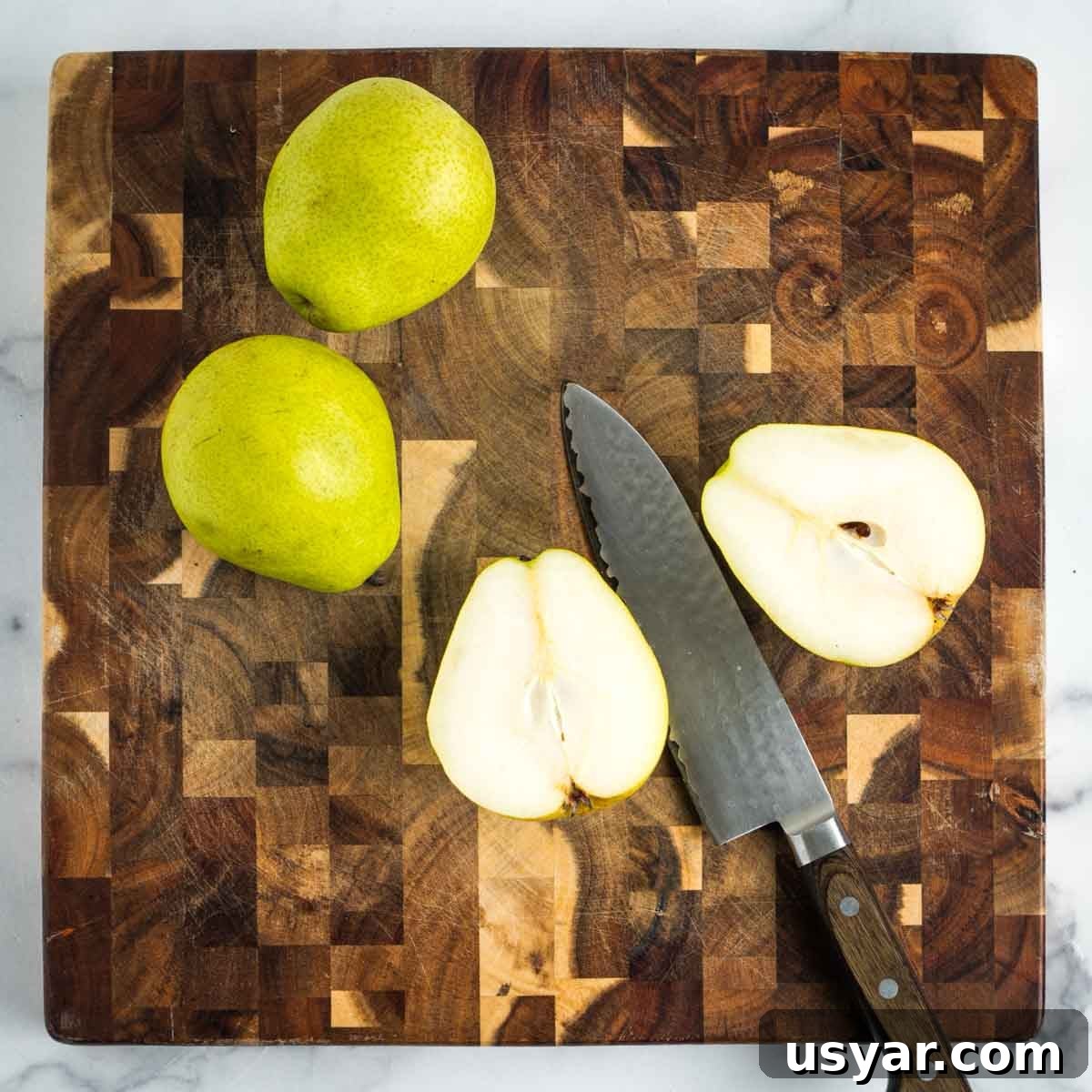 Oven Baked Pears with Almonds and Dark Chocolate 6 A pear cut in half, through the stem and core.