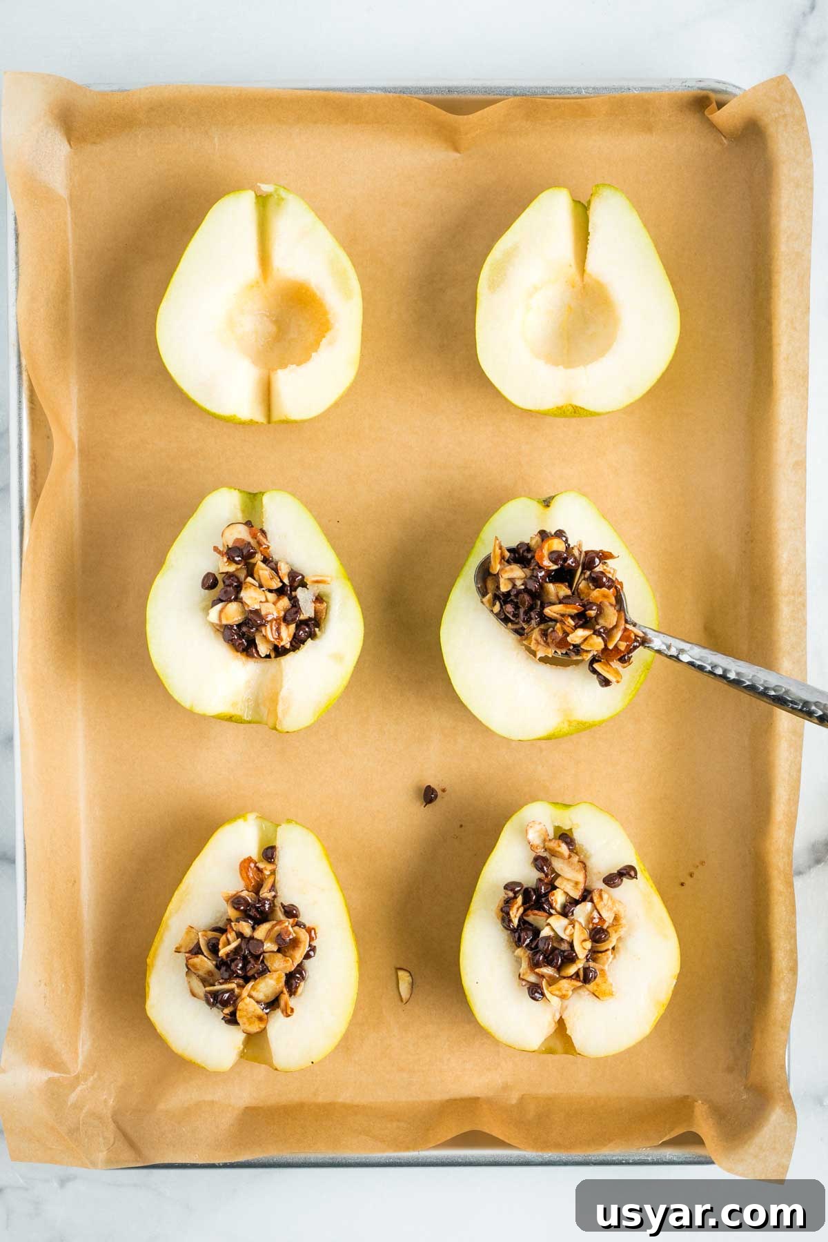 Oven Baked Pears with Almonds and Dark Chocolate 9 Spooning an almond and chocolate mixture into the cavities of pear halves.