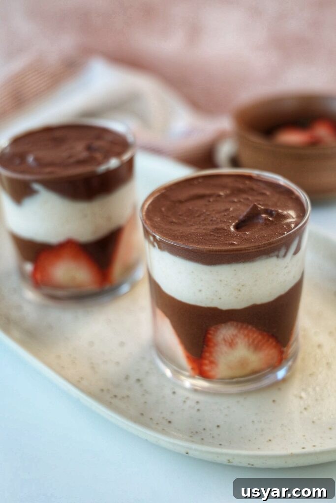 Two-Ingredient Chocolate Mousse Recipe 2 Two jars of chocolate mousse with strawberries.