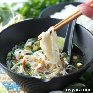 Shortcut Chicken Pho Recipe for Vietnamese Pho Ga 19 thumbnail photo of chopsticks lifting a mouthful of noodles up out of the bowl of pho soup.
