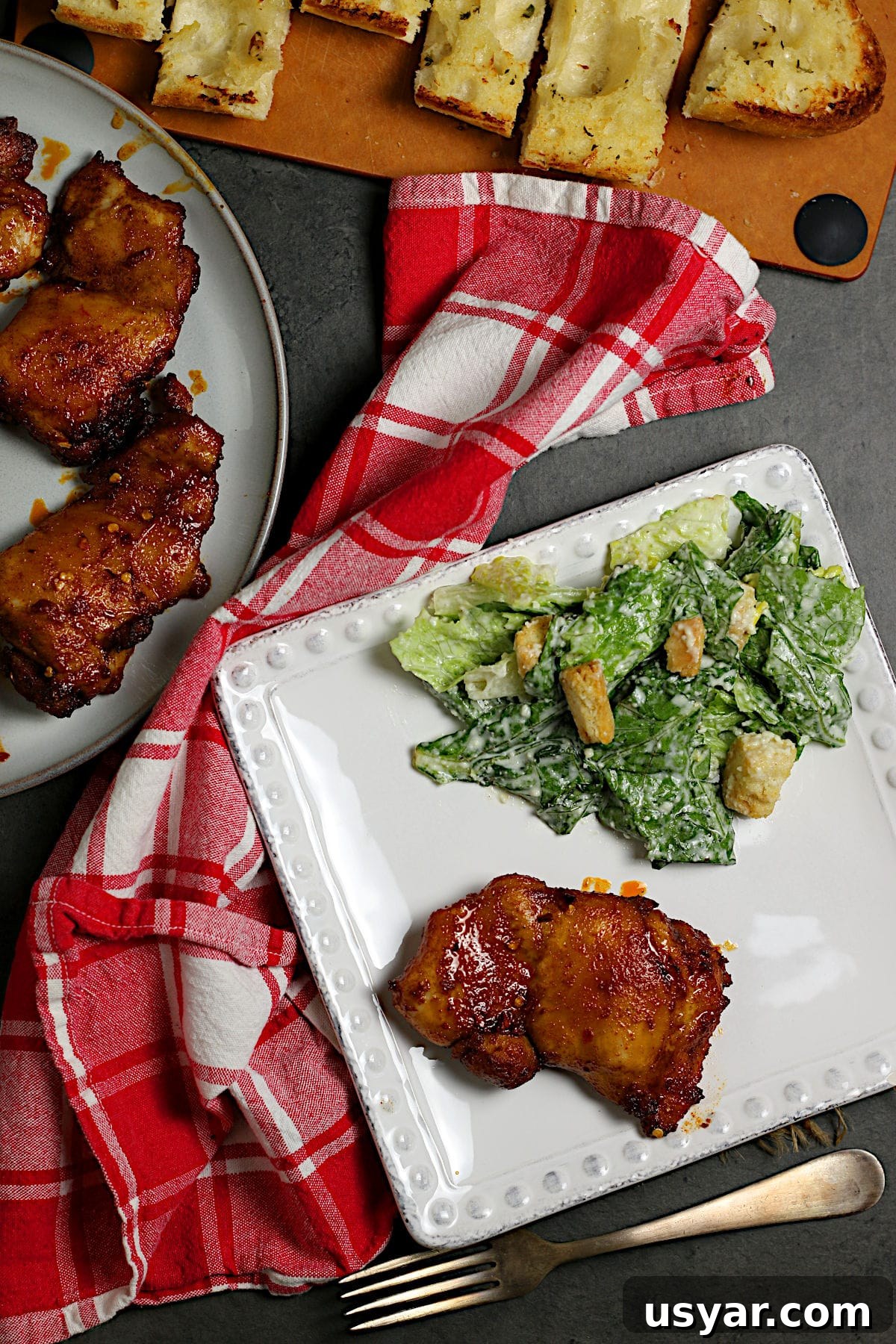 Hot Honey-Glazed Chicken Thighs Recipe 3 An overhead photo of a Hot Honey Glazed Chicken Thigh on a white plate.