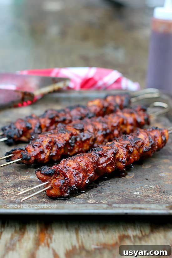 Hot Honey-Glazed Chicken Thighs Recipe 8 Closeup shot of grilled barbecue chicken skewers on a tray