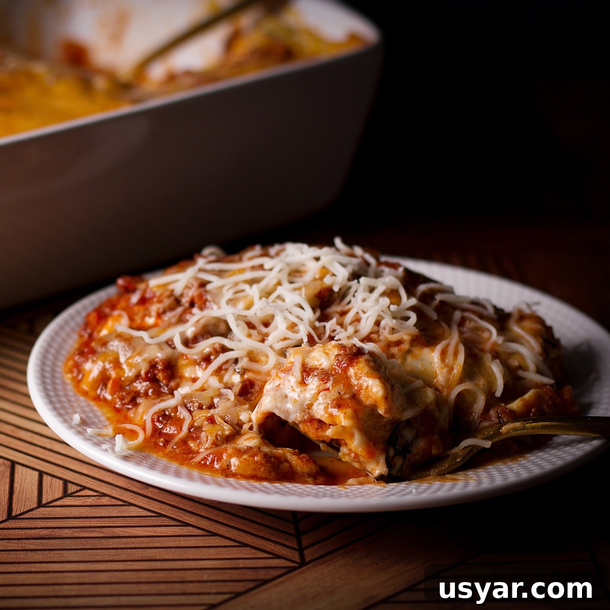 A plate with a serving of lasagna bolognese on it.