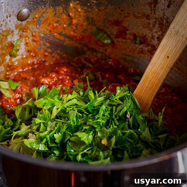 Cheesy Sausage Lasagna Recipe with Homemade Marinara 4 Stirring fresh herbs into homemade marinara sauce.