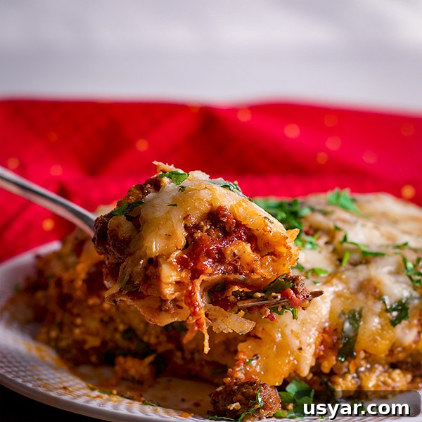 Cheesy Sausage Lasagna Recipe with Homemade Marinara 8 Taking a bite of classic homemade lasagna with Italian sausage.