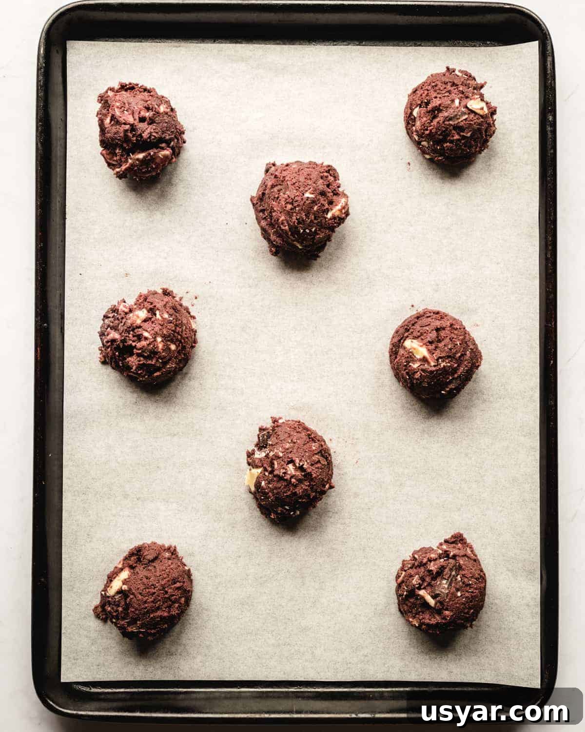 Fudgy White Chocolate Chip Cookie Recipe 3 balls of cookie dough ready to be baked