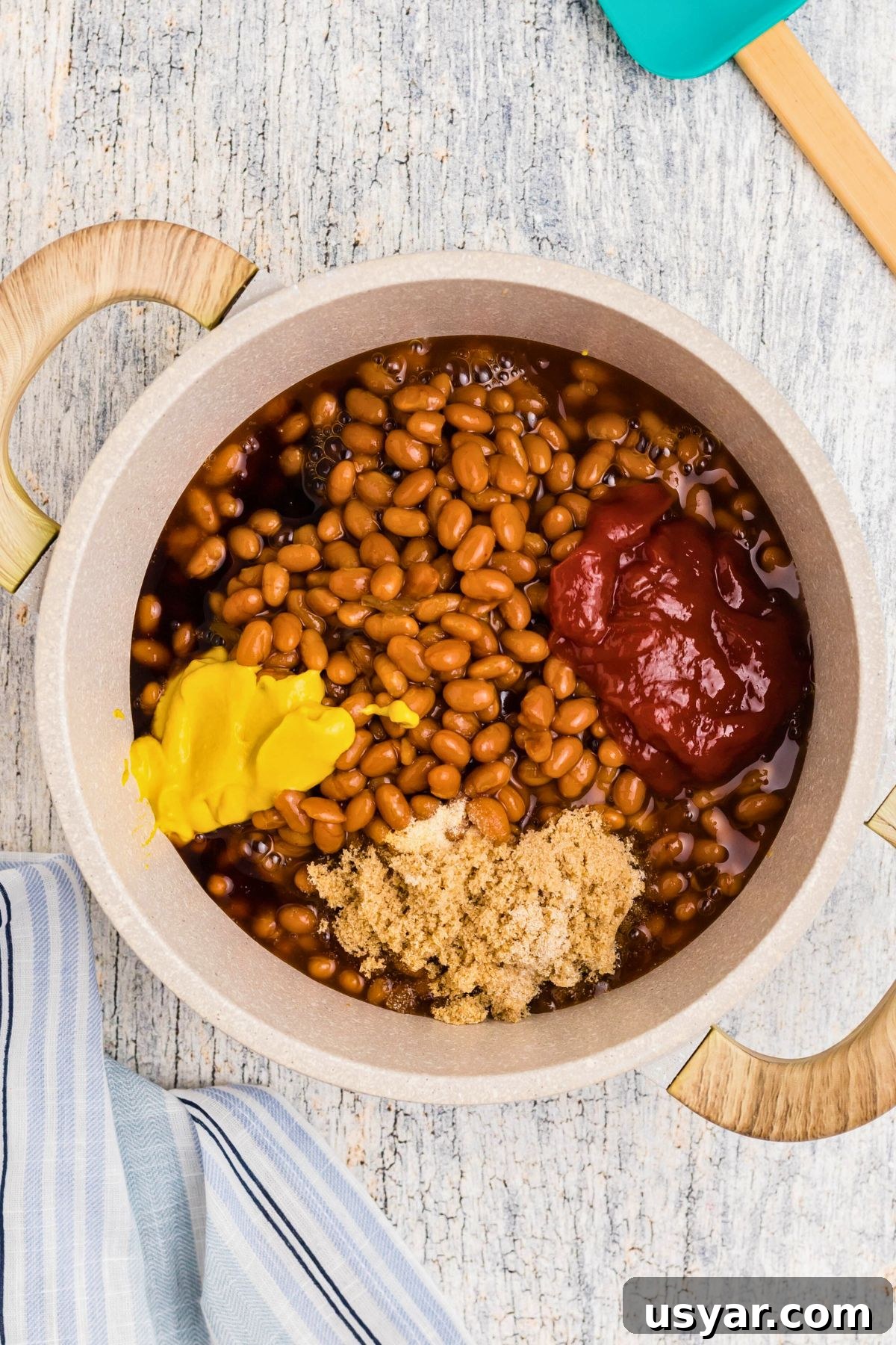 Beanie Weenies Recipe: Classic Hot Dogs in Baked Beans 5 Mustard, ketchup and other ingredients being added to saucepan.