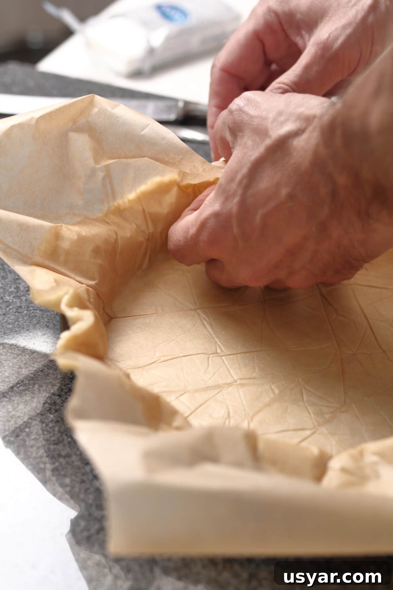 Low-Carb Dessert Baking Tips and Tricks for Perfect Results 11 A pie crust being pushed into a pie tart shell with parchment paper.