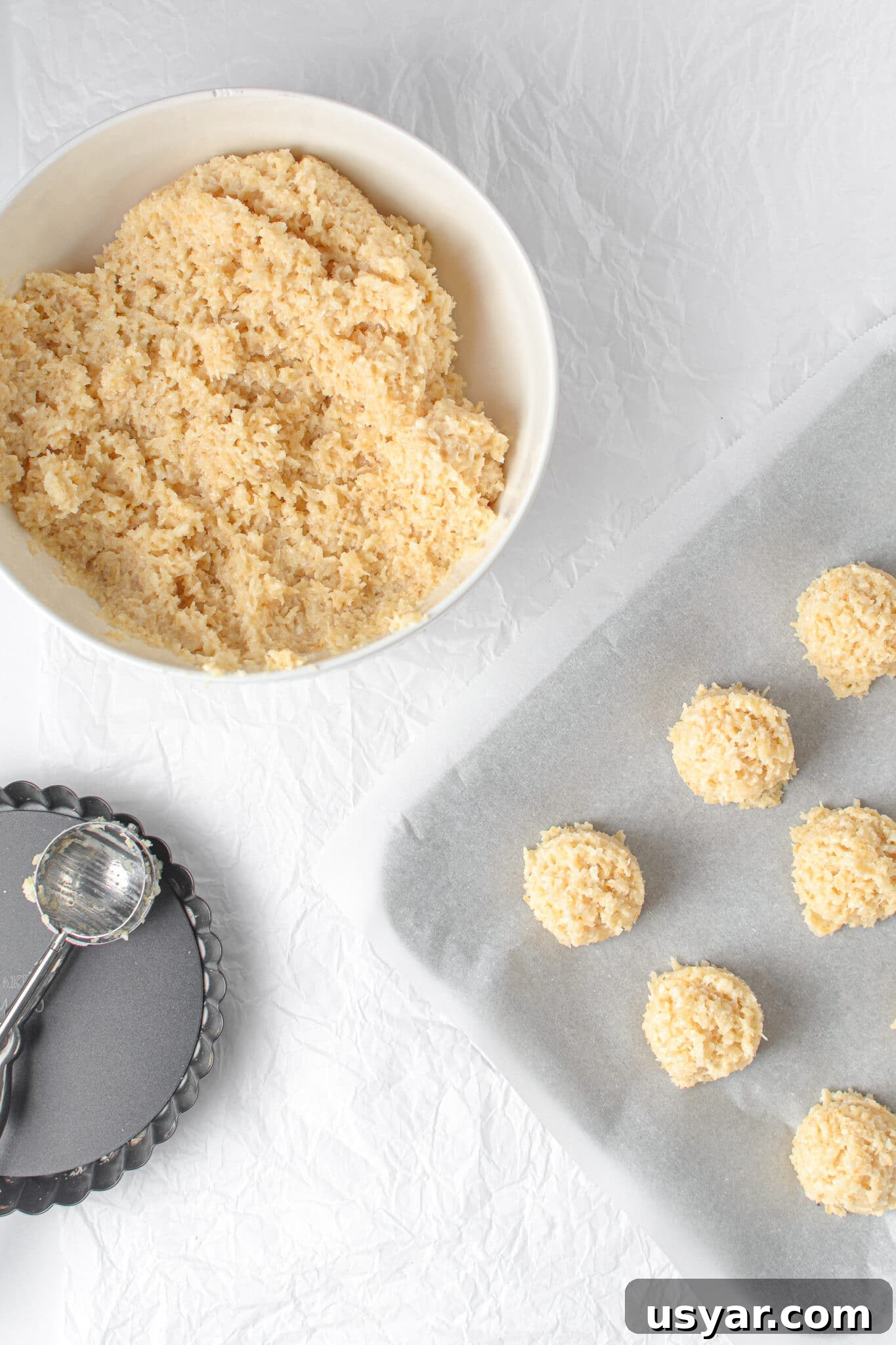 Low-Carb Dessert Baking Tips and Tricks for Perfect Results 8 A bowl of cookie dough and cookie tray covered with parchment paper and mounds of scooped cookie dough.
