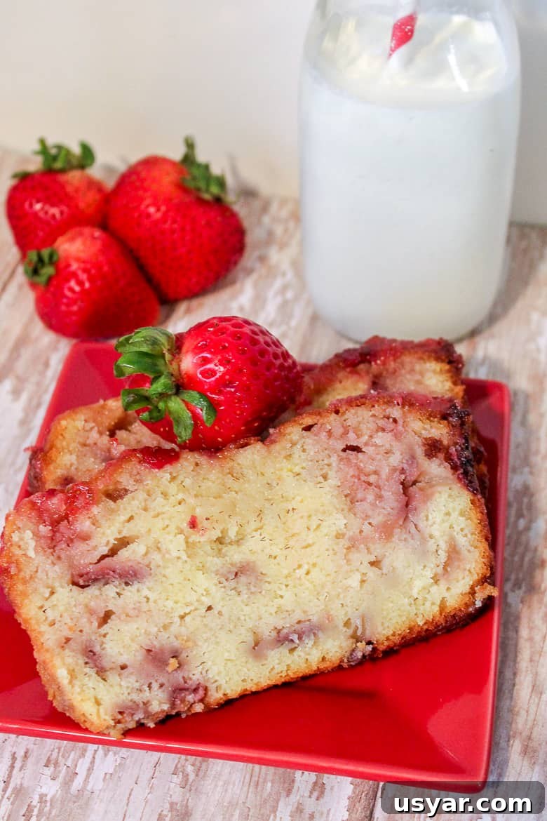 Strawberry Yogurt Pound Cake Recipe 3 Two slices of strawberry yogurt pound cake on red plate with fresh strawberries.