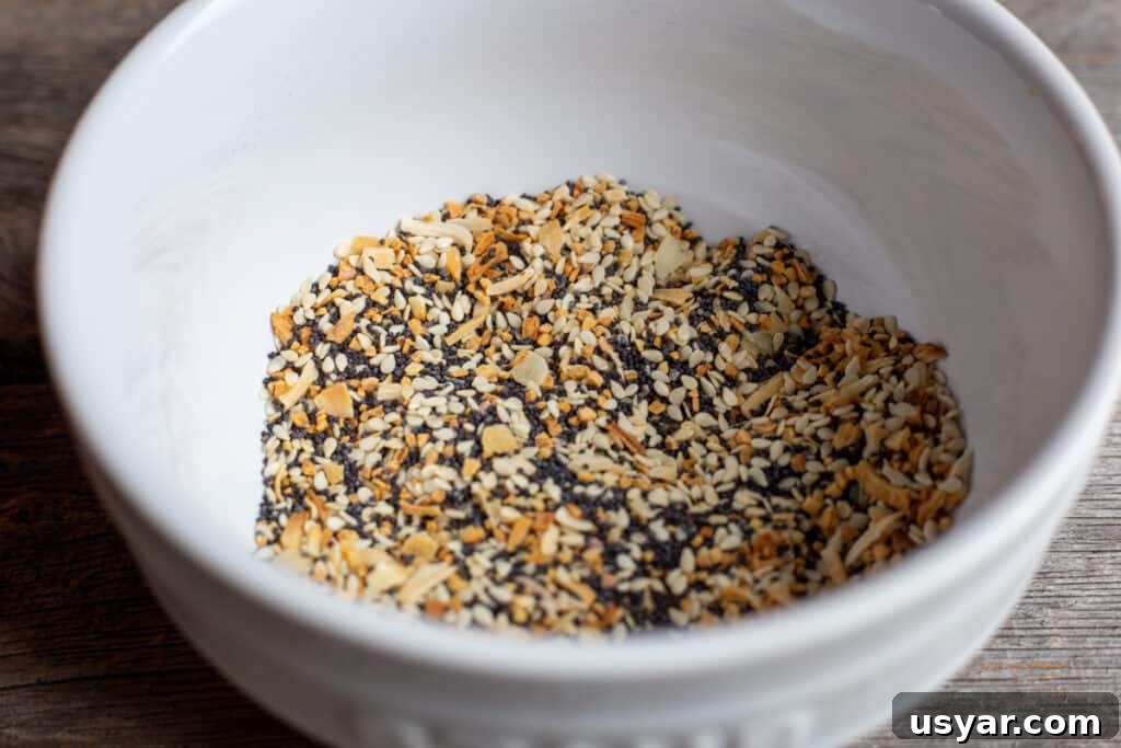 Crusty Herbed Beer Bread Recipe with Garlic and Thyme 5 Everything bagel seasoning in a white bowl on a wooden board.
