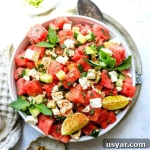 White bowl with ingredients mixed together to make watermelon salad with feta.