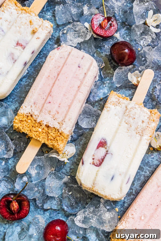 cherry cheesecake popsicles laid out over ice cubes
