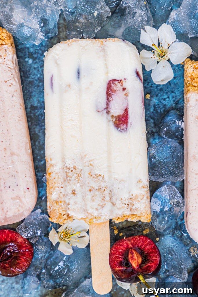 cherry cheesecake popsicles laid out over ice cubes