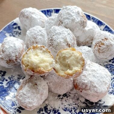 Classic Southern Sausage Gravy Recipe 15 A blue plate with biscuit beignets on it, covered in powdered sugar.