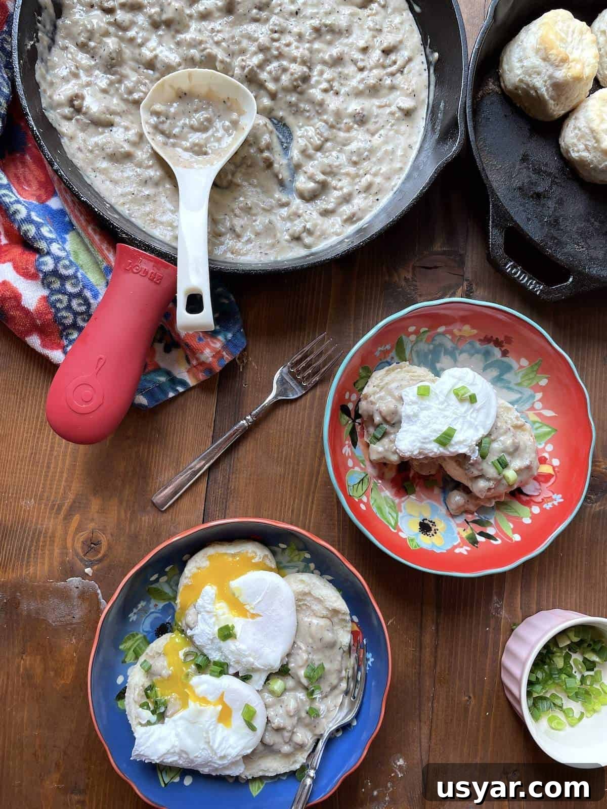 Classic Southern Sausage Gravy Recipe 9 Two bowls of biscuits and gravy and a cast iron skillet filled with sausage gravy.