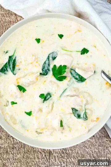 Instant Pot Olive Garden copycat Chicken Gnocci soup in a white bowl, garnished with fresh herbs.