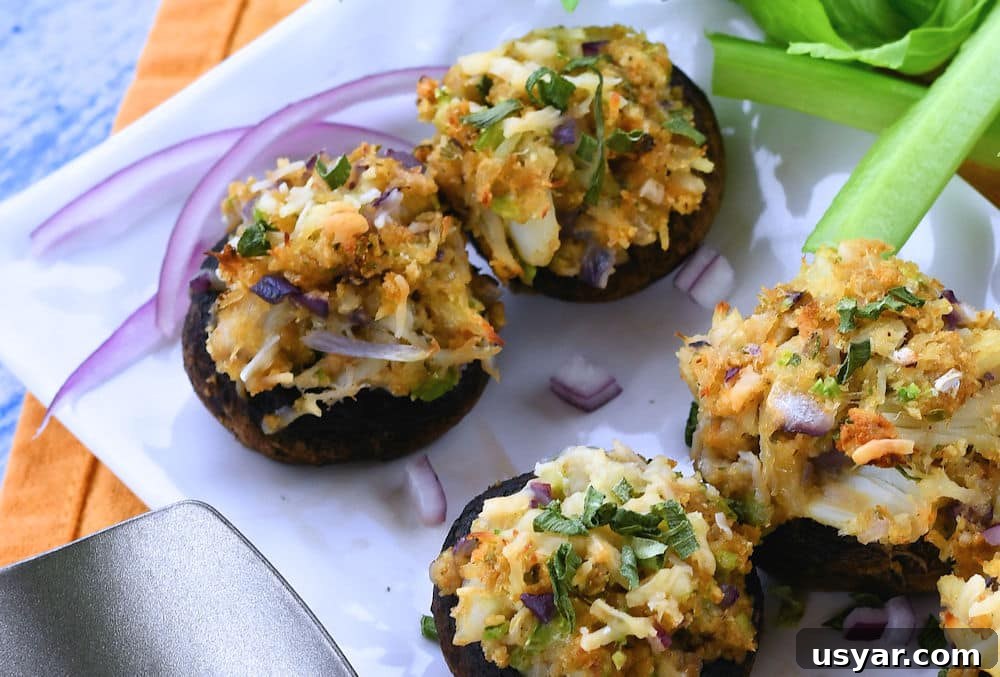 Crab Stuffed Mushrooms for Air Fryer or Oven 8 stuffed mushrooms after baking and placed on a white rectangle serving dish