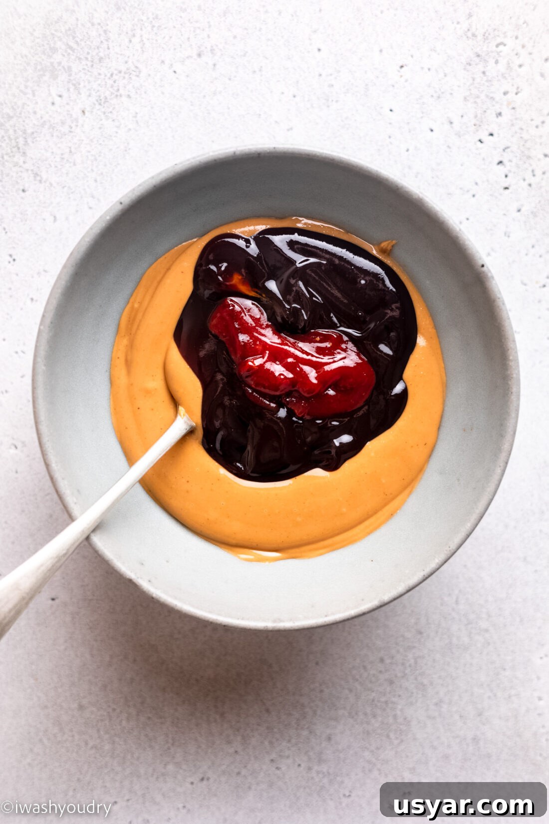 Thai Chicken Satay Recipe with Peanut Dipping Sauce 8 Peanut butter, hoisin, lime and sriracha sauce in white bowl.