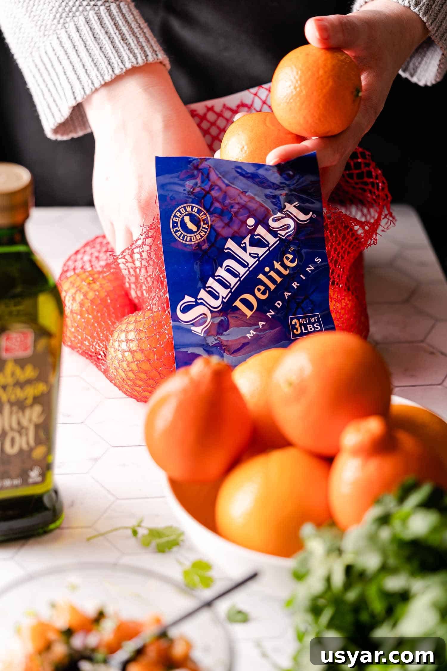 Citrus Herb Salmon with Orange and Red Onion Salsa 4 hands removing Mandarins from net bag
