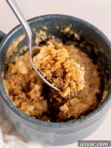 A bite of banana bread mug cake on a spoon.