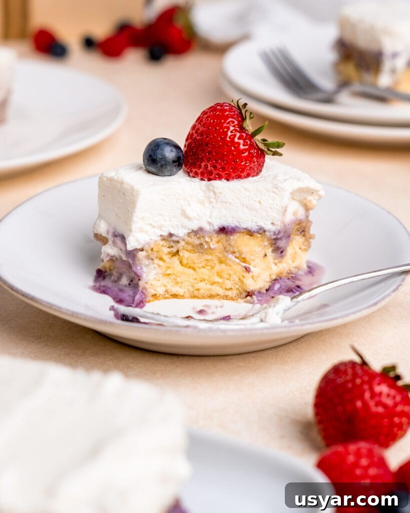 Creamy Milk and Berry Layer Cake 9 A slice of cake with a bite taken out of it.