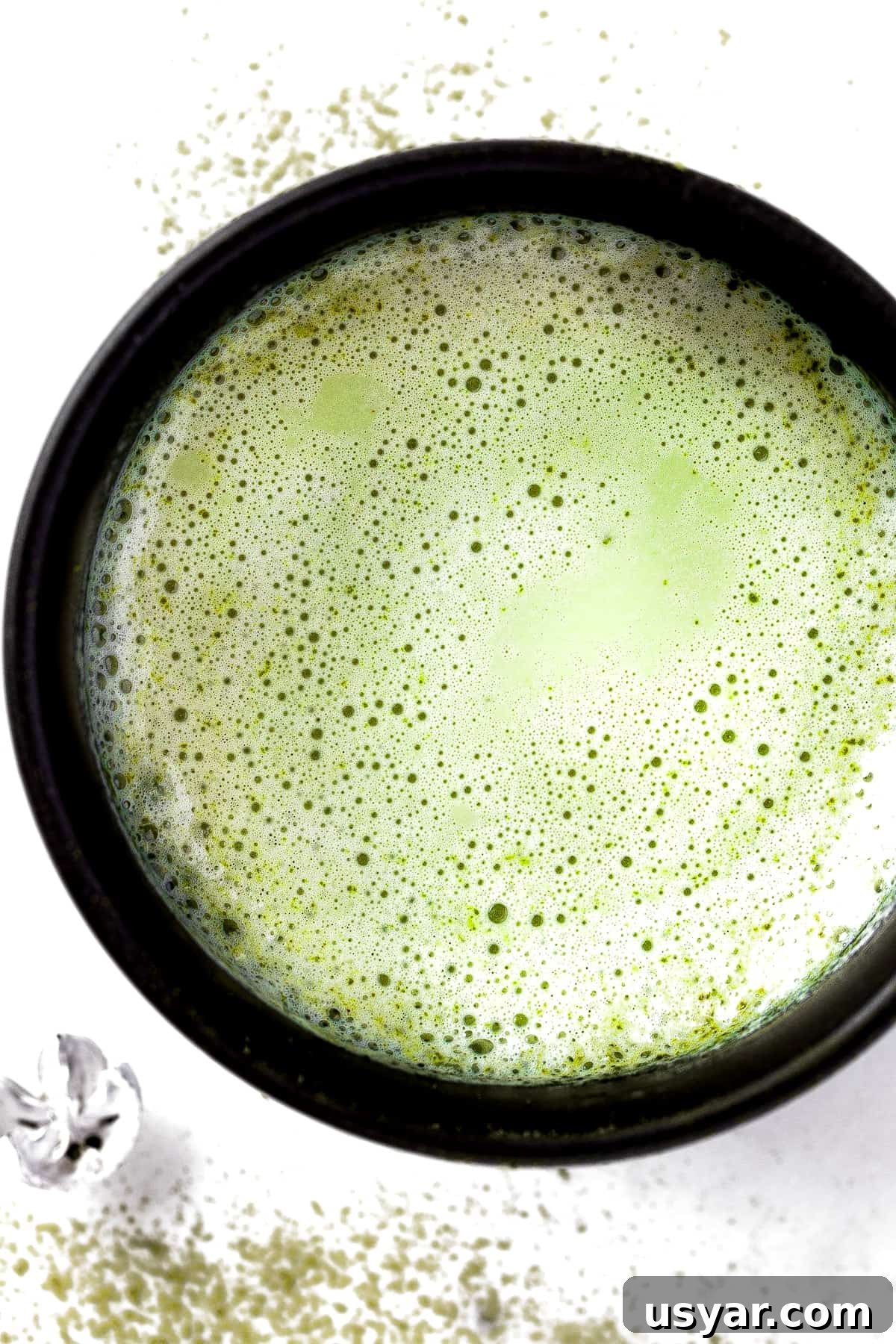 Oat Milk Matcha Latte Recipe 2 Overhead view of a frothy oat milk matcha latte in a black mug.