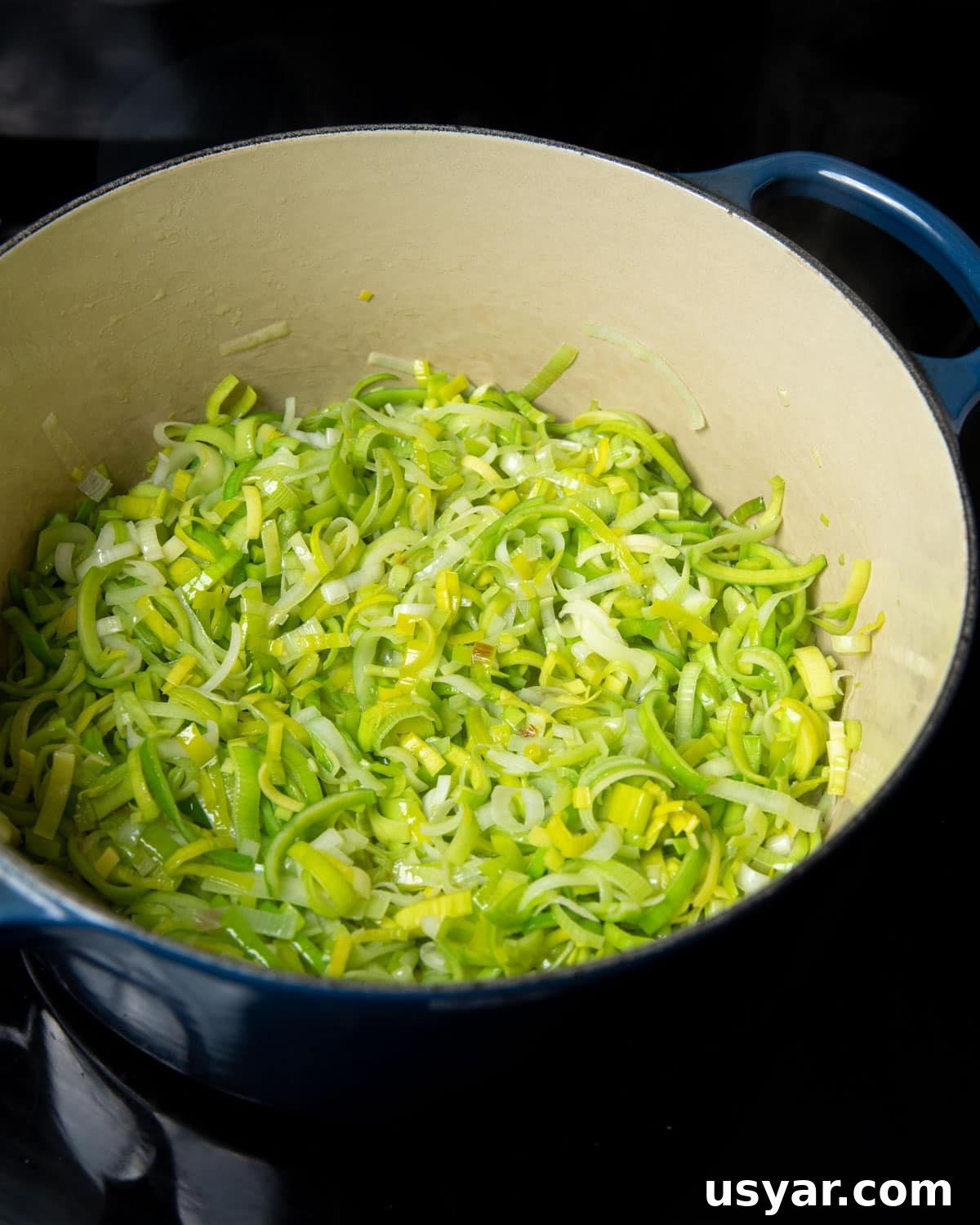 Creamy Vegan Leek and Potato Soup Vichyssoise 10 Photo of sliced leeks cooking in a casserole pan.