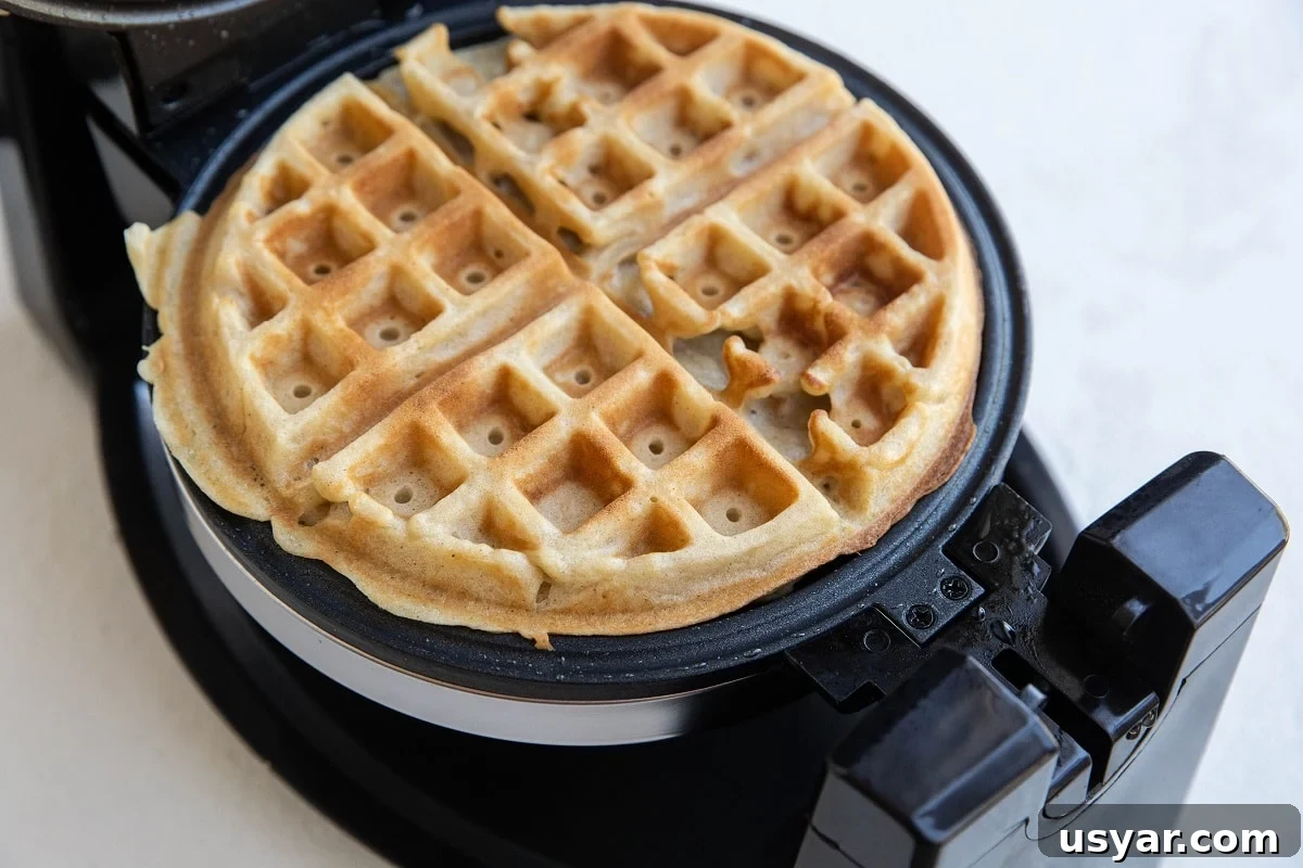 Waffle maker with finished waffle all golden brown and perfect