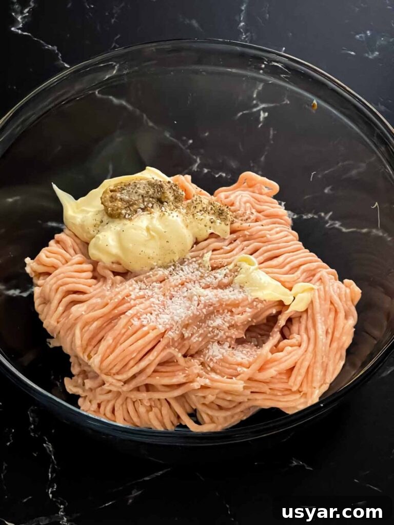 Carolina-Style Grilled Chicken Burger Recipe 13 Ground chicken with other ingredients in a glass bowl.