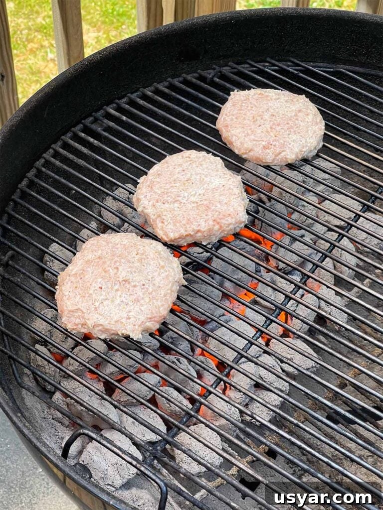Carolina-Style Grilled Chicken Burger Recipe 17 Chicken burgers cooking on a charcoal grill.