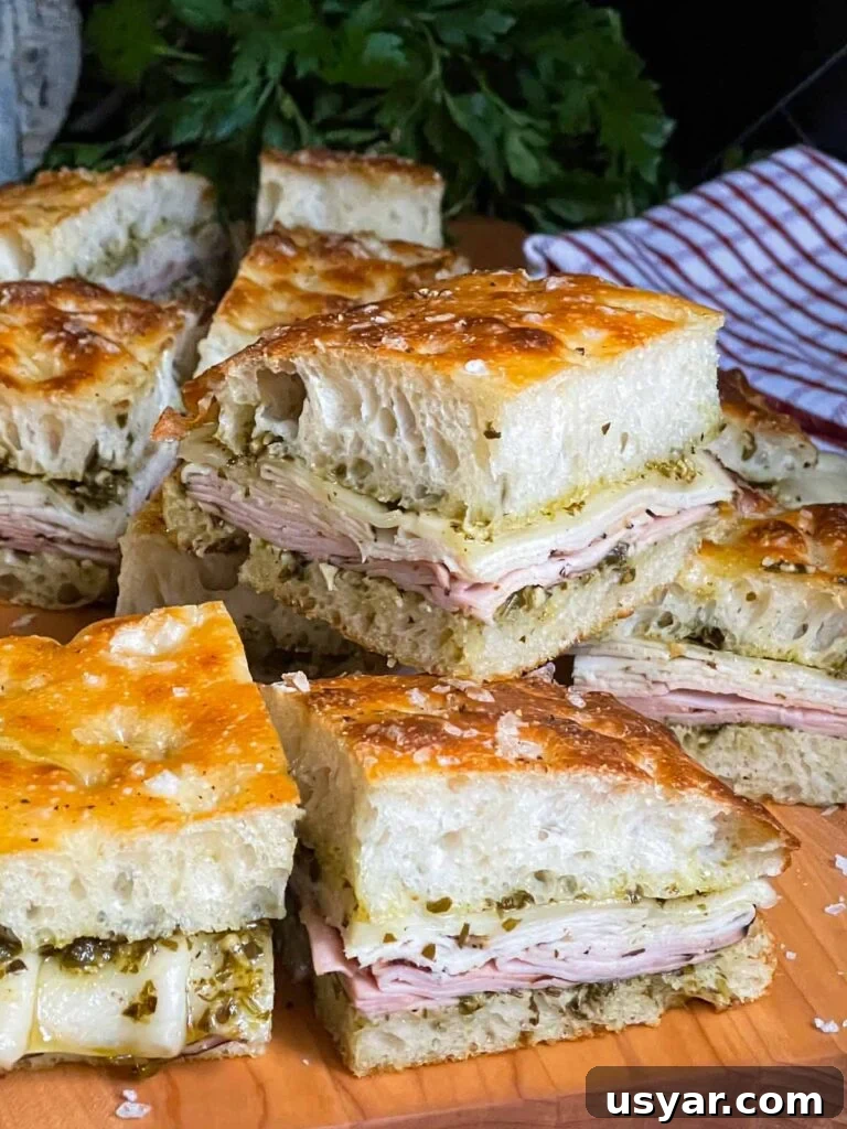 Carolina-Style Grilled Chicken Burger Recipe 22 Sliced pesto focaccia sandwiches, on a cutting board.