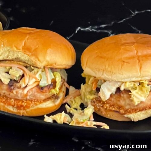 Carolina-Style Grilled Chicken Burger Recipe 24 Grilled Carolina chicken burgers on a black plate.