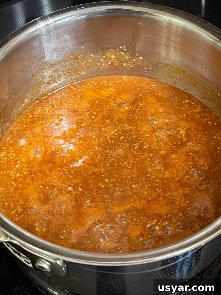 Carolina-Style Grilled Chicken Burger Recipe 7 Barbecue sauce cooking in a sauce pan.