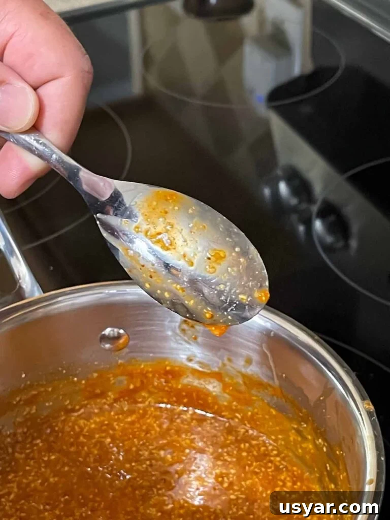 Carolina-Style Grilled Chicken Burger Recipe 8 Showing the thickness of the sauce on the back of a spoon.