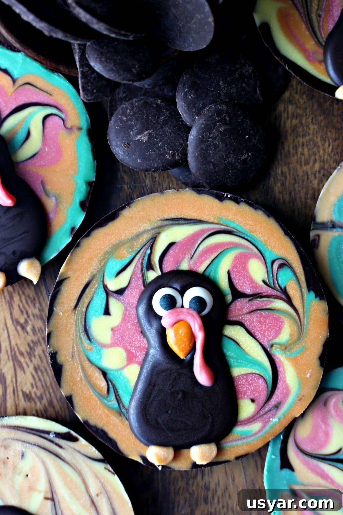 DIY Chocolate Turkey Recipe for Thanksgiving 2 Chocolate Bark Turkey made in a muffin tin with swirled colored chocolate in the background.