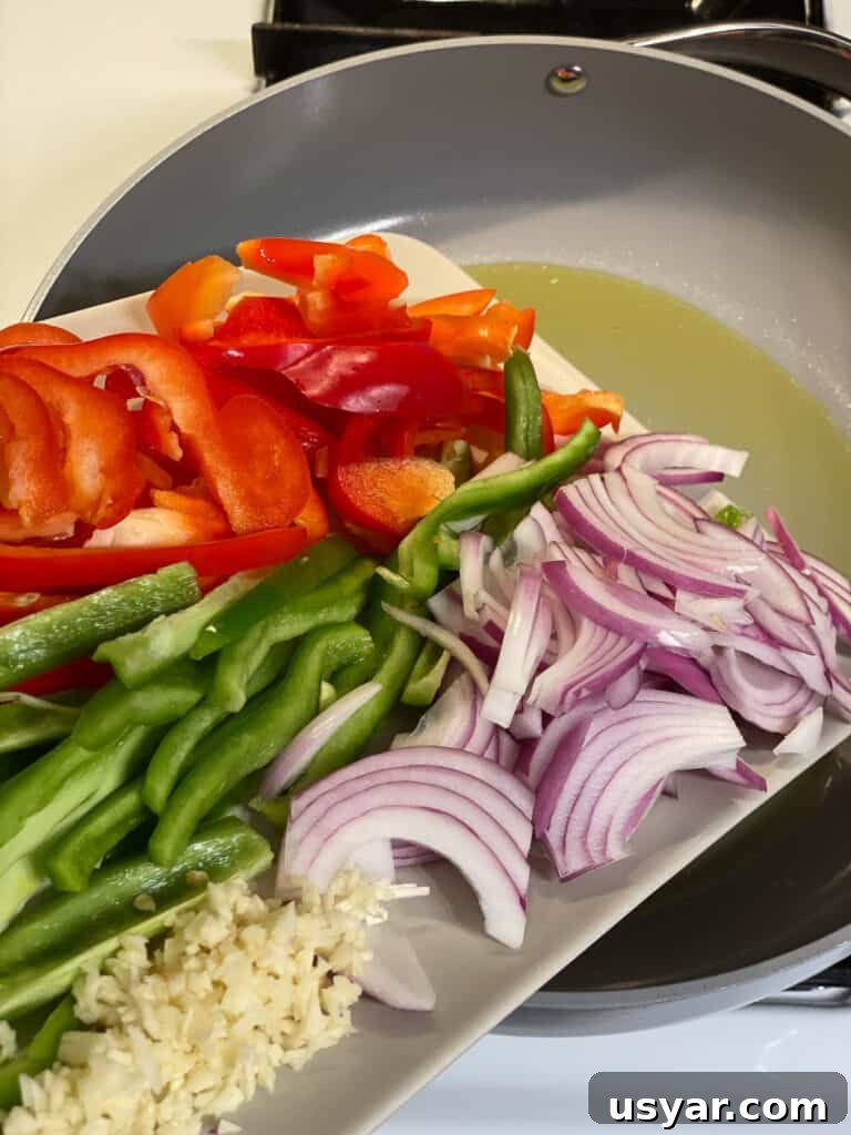 sliced vegetables for Vegan Fajita Tacos being poured into a pan