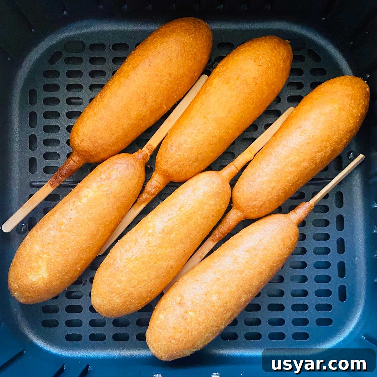 Crispy Air Fryer Corn Dogs Recipe 5 cooked corn dogs in air fryer basket