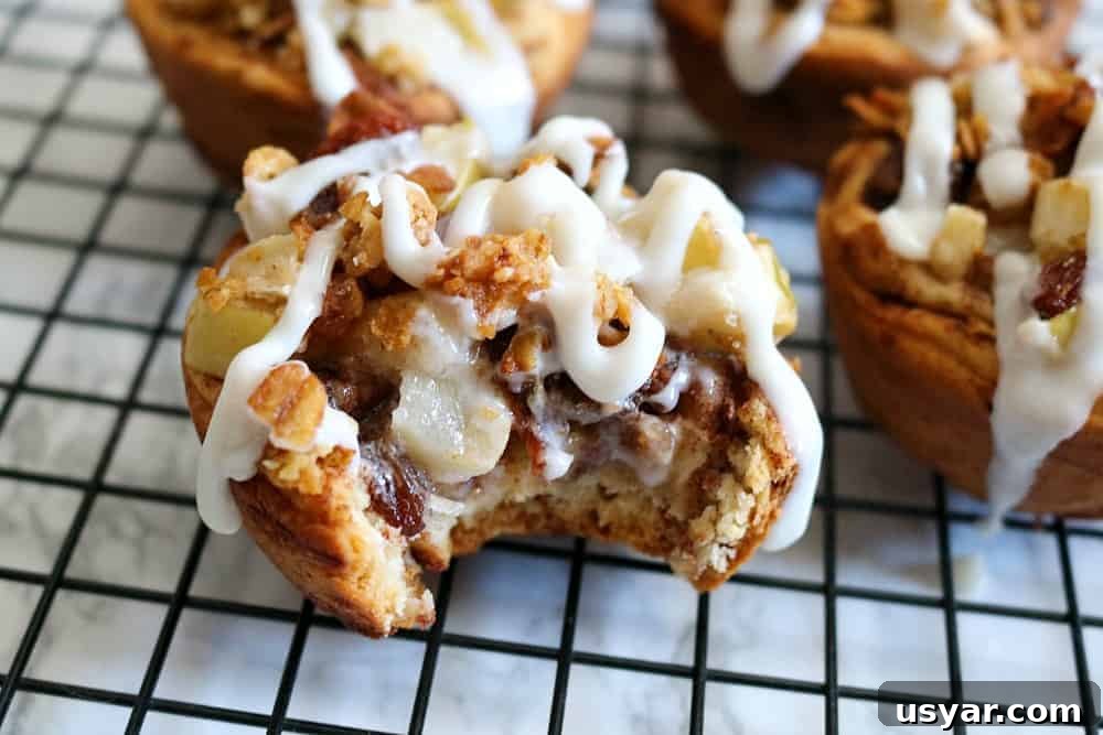cinnamon roll apple pies with apple filling on wire rack. 
