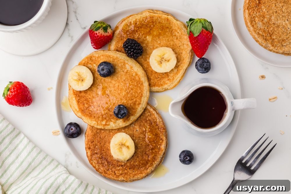 High Protein Cottage Cheese Blender Pancakes 10 Plate of 3 pancakes with fruit and a small jug of syrup
